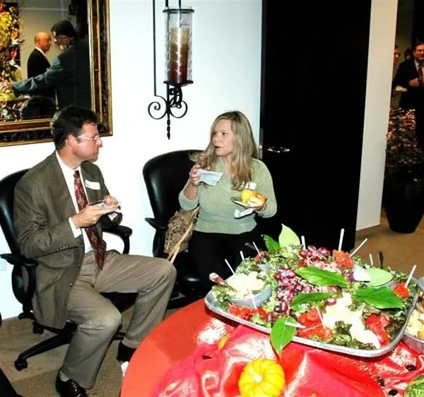 Two people sitting at a table with food on it