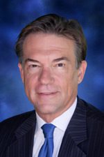 A man in suit and tie with blue background